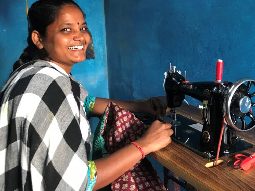 Eine junge indische Frau an einer Nähmaschine.
