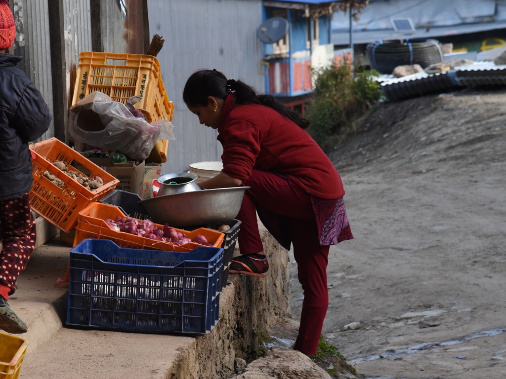 Das Foto zeigt ein junges Mädchen, das in ärmerlicher Umgebung am Strassenrand in Nepal arbeitet, Dort in Nepal arbeitet auch die Partnerorganisation des Weltgebetstags, Sansthagat Bikas Sanjal, Das Foto stammt vom WGT eV